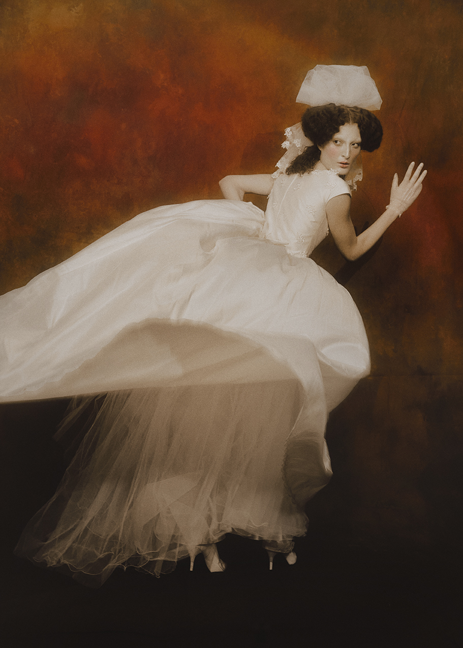 White dress in motion against a painted amber backdrop